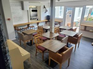 a restaurant with tables and chairs in a room at Beachside 1 in Saint Helier Jersey