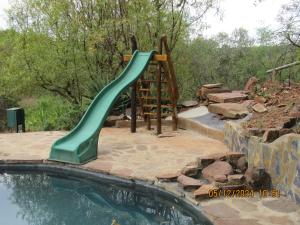 a green water slide in a pool of water at Honey Nest Camp in Derby +58 photos