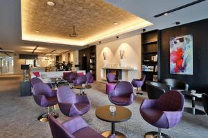 a waiting room with purple chairs and tables at Hotel Schempp in Bobingen