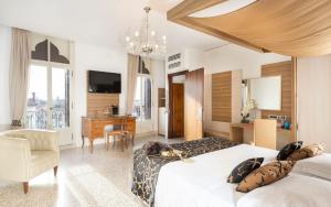 a bedroom with two beds and a desk and a television at Maison Spada in Venice