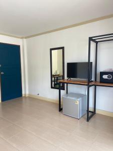 a room with a tv and a table and a mirror at Lemon Inn in Ko Lanta