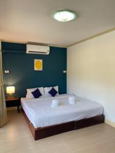 a bedroom with a large bed with a blue wall at Lemon Inn in Ko Lanta