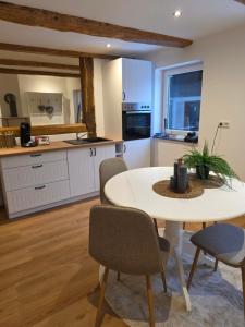 a kitchen with a table and chairs in a room at Unter den Balken - mit Ofen & Ruhe Keine Monteure! in Nörten-Hardenberg