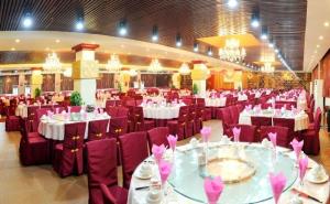 un salón de banquetes con mesas blancas y sillas moradas en West Street Vista Hotel, en Yangshuo