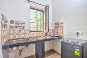 a bathroom with a sink and a window at Hotel Calangute bay in Calangute +13 photos