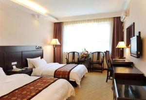 Habitación de hotel con 2 camas y escritorio en West Street Vista Hotel, en Yangshuo