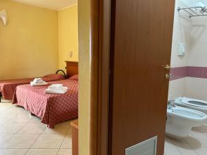 a hotel room with two beds and a toilet at Residence Perla - Costa in Salve