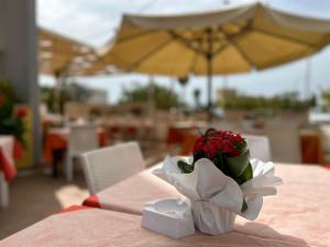 a vase filled with flowers sitting on a table at Residence Perla - Costa in Salve +20 photos