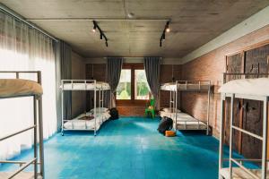 a room with three bunk beds and a brick wall at Villa Xiav - Flipside Adventures in Bản Kin +63 photos