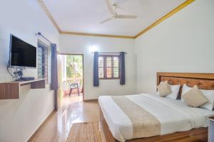 a bedroom with a bed and a flat screen tv at Hotel Calangute bay in Calangute