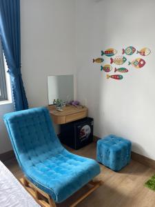 a blue chair in a room with a desk at HOTEL vùng vịnh in Cầu Sông Kinh