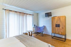 a bedroom with a bed and a chair and a television at St Anastasia Hotel in Burgas