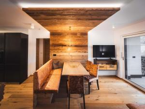 a dining room with a table and chairs and a tv at Paradeis Apartments in Mühlbach