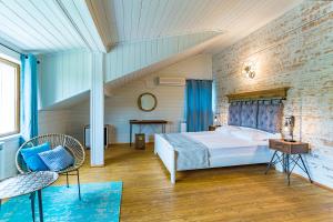 a bedroom with a bed and a brick wall at St Anastasia Hotel in Burgas