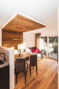 a dining room and living room with a table and chairs at Paradeis Apartments in Mühlbach