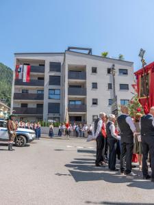 a group of people standing in the street watching a parade at Paradeis Apartments in Mühlbach +104 photos