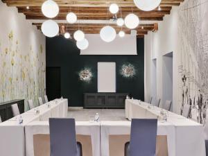 a conference room with white tables and chairs and lights at Hotel Continental in Opatija