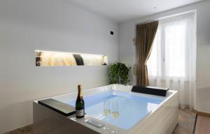 a bath tub with two glasses and a bottle of wine at Flá Suite Castello in Cagliari +81 photos