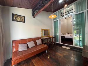 a living room with a couch and a bedroom at Reuan Vilawan Waterfront in Ban Nong Chaeng