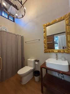 a bathroom with a toilet and a sink and a mirror at Reuan Vilawan Waterfront in Ban Nong Chaeng