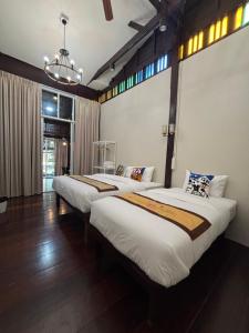 a bedroom with two beds in a room at Reuan Vilawan Waterfront in Ban Nong Chaeng