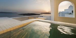 a view from a balcony of a large body of water at Tzekos Villas in Fira