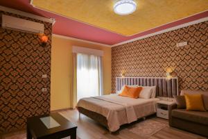 a bedroom with a bed and a couch at Hotel Number One in Gjirokastër
