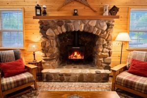 a living room with a stone fireplace in a log cabin at Chipmunk Lodge by NW Comfy Cabins in Leavenworth