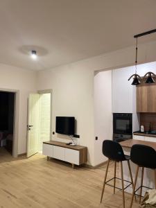 a living room with a television and a table and chairs at Home Kodjori in Kojori