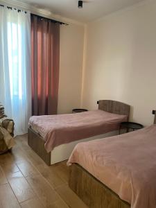 a bedroom with two beds and a window at Home Kodjori in Kojori