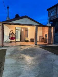 a house with a patio with a swing at Home Kodjori in Kojori