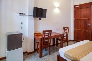 a room with a table and chairs and a television at Grand Ranketha Resort in Kalutara