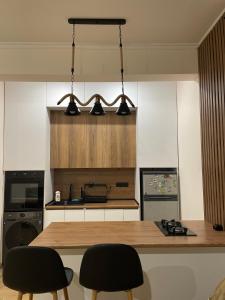a kitchen with a wooden table and two chairs at Home Kodjori in Kojori