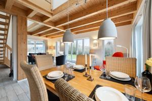 a dining room and living room with a wooden table and chairs at Rapsblütenhaus in Bohnert