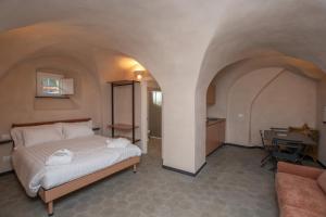 a bedroom with a bed and a desk in a room at Locanda Mirei in Finale Ligure