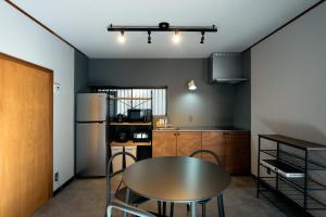 a kitchen with a table and chairs in a room at SAUNARF Aoshima in Miyazaki