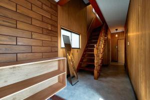 a hallway of a house with wooden walls and stairs at SAUNARF Aoshima in Miyazaki