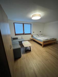 a room with a bed and a couch and a table at Chalet pri studenom potoku in Stará Lesná +44 photos