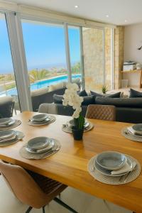 a dining room table with plates and flowers on it at Lirios 182 Cumbre del Sol in Benitachell