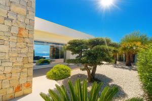 a house with a tree in front of a building at Lirios 182 Cumbre del Sol in Benitachell