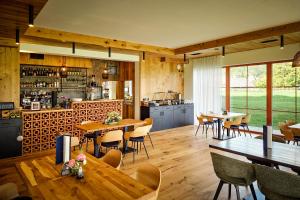 a restaurant with wooden floors and tables and chairs at Resort Vysoká Lípa - Stodola, Chalupa - Barn, Cottage in Jetřichovice