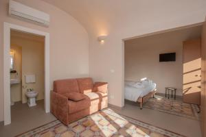 a living room with a chair and a bed at Locanda Mirei in Finale Ligure