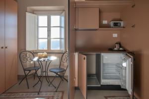a small kitchen with a table and chairs and a refrigerator at Locanda Mirei in Finale Ligure