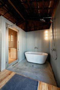 a large white tub in a bathroom with a shower at SAUNARF Aoshima in Miyazaki +28 photos