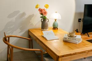 a table with a vase with flowers and a book at LeD Courtyard Homest ay乐东小院民宿 in Beijing