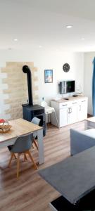 a living room with a table and a stove at Maison l'Escale du port in Berville-sur-Mer