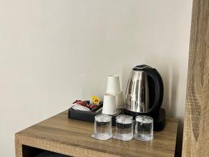 a table with a coffee maker and glasses on it at Mass Paradise Hotel in Aqaba