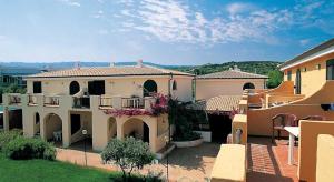 a large house with a balcony in a yard at Fruit Village Tropea Baia della Rocchetta Soft all Inclusive in Conidoni