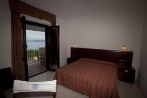 a bedroom with a bed and a large mirror at Fruit Village Tropea Baia della Rocchetta Soft all Inclusive in Conidoni +20 photos
