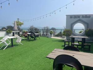 a patio with picnic tables and chairs on a roof at Elements Hostel And Coworking in Weligama